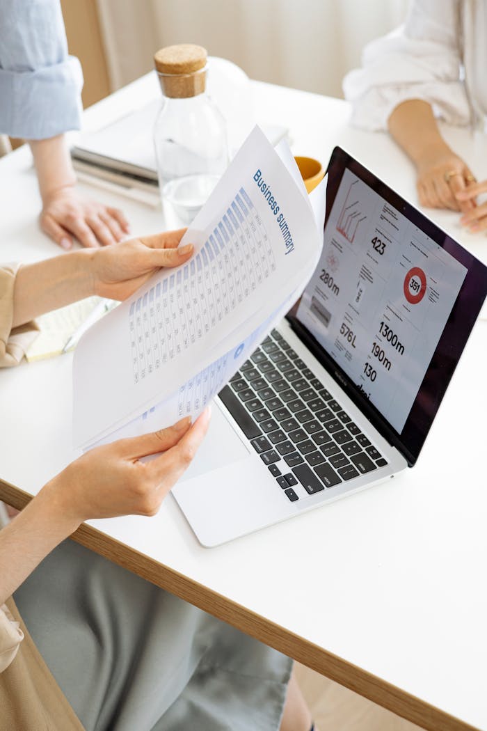 creative Modern office setting with a business report and laptop display on a white desk.